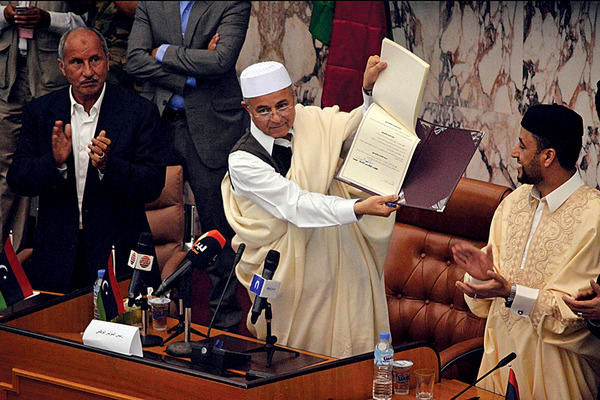 Nuri Abu Sahmain (C), the new head of Libya’s General National Congress (GNC), raises the signature sheet during a signing ceremony for the law on elections of the constituent body for the drafting of a new constitution, in Beida [photo credit: Reuters]