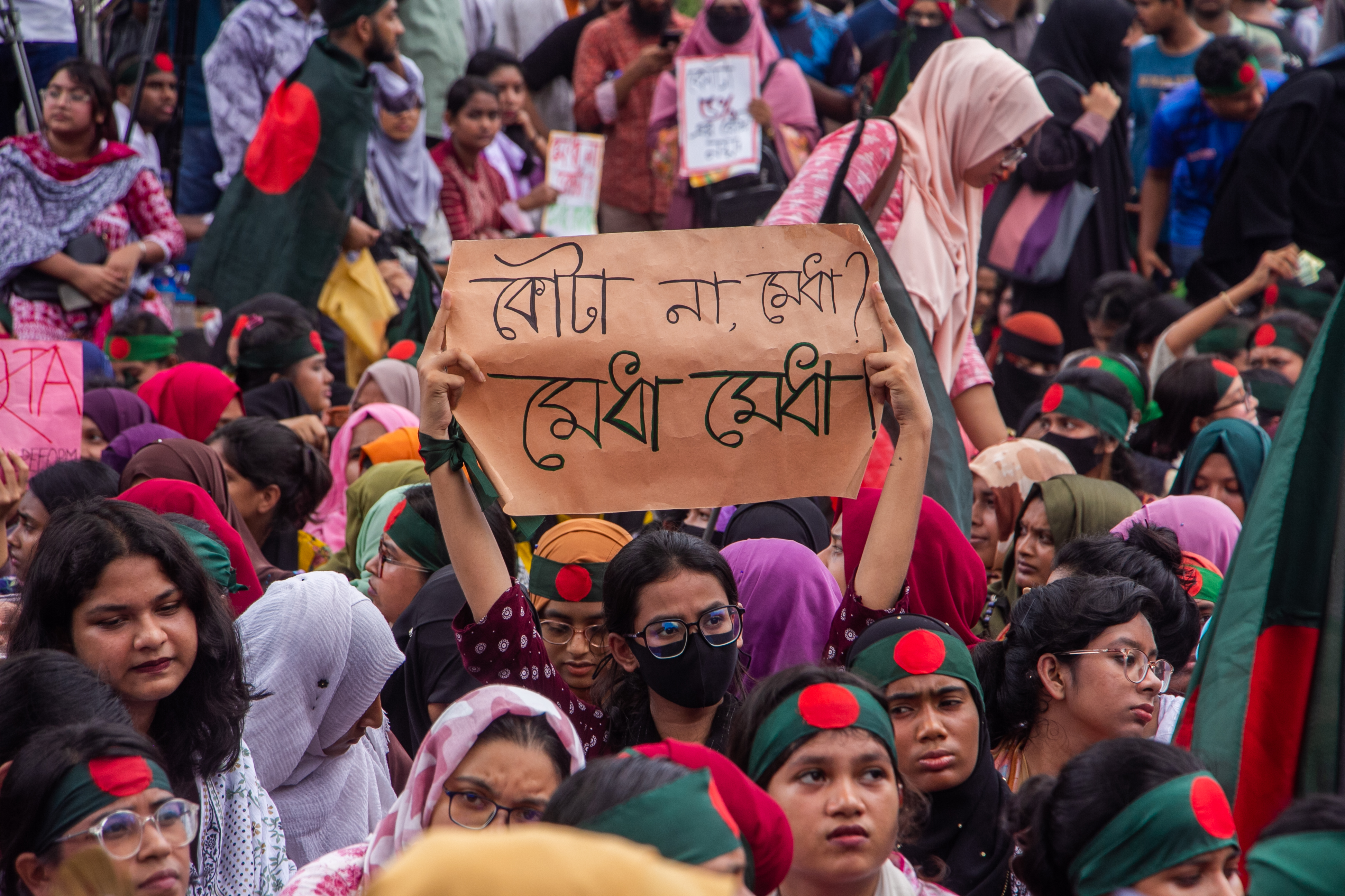Quota reform protest in Bangladesh with a sign reading "Not quotas, merit!" (photo credit: Rayhan9d via Wikimedia Commons)