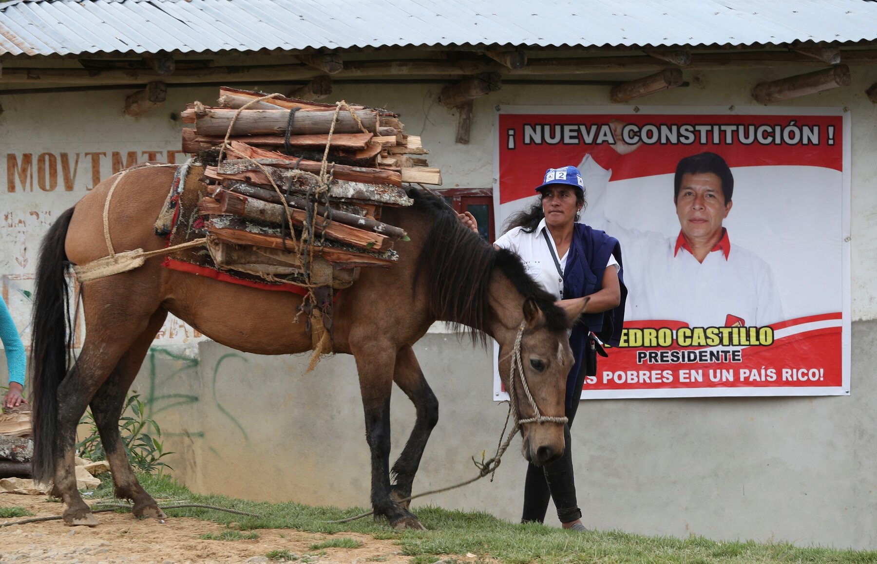 Peruvian in front of Pedro Castillo's election poster promising a new constitution (photo credit: AP / Martin Mejia) Peruvian in front of Pedro Castillo's election poster promising a new constitution (photo credit: AP / Martin Mejia)