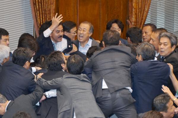 Japanese lawmakers of the House of Councilors scuffled during a vote of the upper house special committee for the security-related bills in Tokyo, Japan, on Sept. 17. Opponents of the bill have said the law would lead to unwanted Japanese involvement in U.S.-led conflicts around the world, and Japan press reported Monday the details on the landmark decision are missing from government records. [photo credit: Keizo Mori/UPI ]