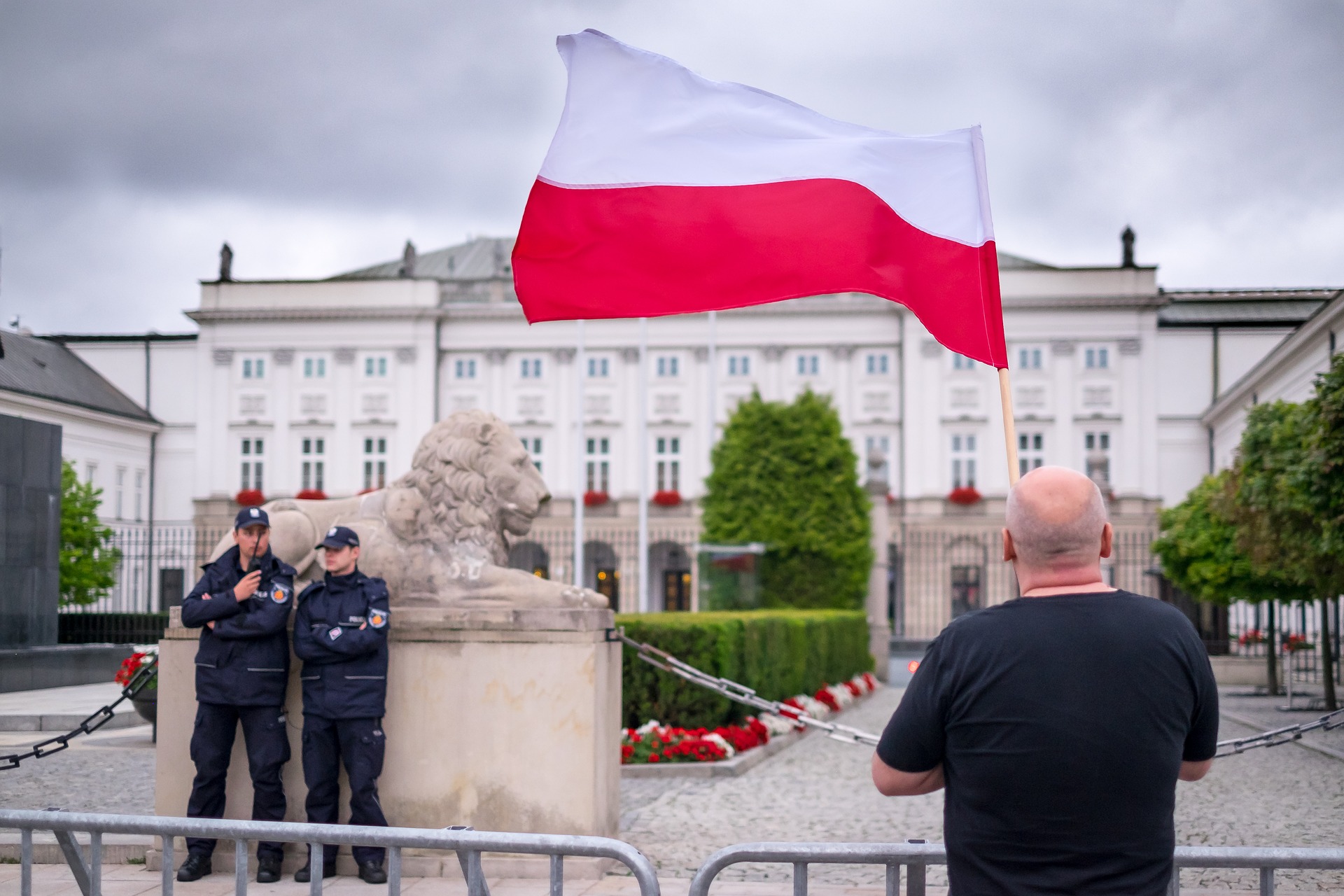 A man holding a Polish flag in front of the presidential palace in Warsaw (Photo credit: Pixabay) A man holding a Polish flag in front of the presidential palace in Warsaw (Photo credit: Pixabay)