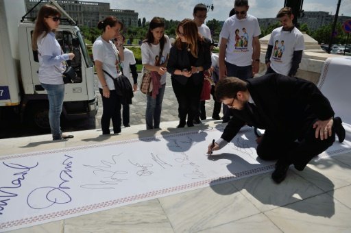 Members of "The Coalition for the Family" symbolically sign as they finish transporting boxes conatining over 3,000,000 signatures to the Romanian Senate (photo credit: AFP) Members of "The Coalition for the Family" symbolically sign as they finish transporting boxes conatining over 3,000,000 signatures to the Romanian Senate (photo credit: AFP)